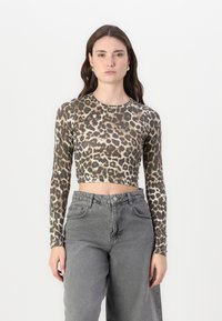 Leopard print crop top with long sleeves in beige and brown tones, paired with high-waisted gray cargo pants.