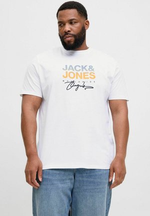 Bijela pamučna majica s "JACK & JONES" logom u plavoj i narančastoj boji, sa stiliziranim rukopisom ispod. Uparena s svijetloplavim trapericama.