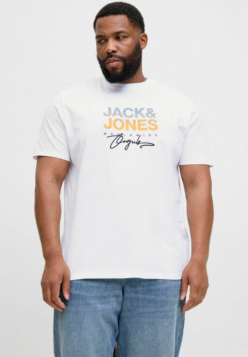 Valge puuvillane T-särk, millel on sinine ja oranž "JACK & JONES" logo ning all käsitsi kirjutatud allkiri. Kombineeritud heledate siniste teksadega.
