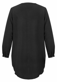 Camicia nera a maniche lunghe con orlo arrotondato, tessuto testurizzato, polsini con bottoni e scollatura semplice. La vista posteriore mostra dettagli di design minimi.