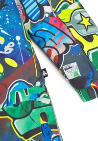 Färgglad pufferjacka med graffiti-mönster i nyanser av blått, grönt, gult och rött; inkluderar en blå dragkedja och distinkta texturer.