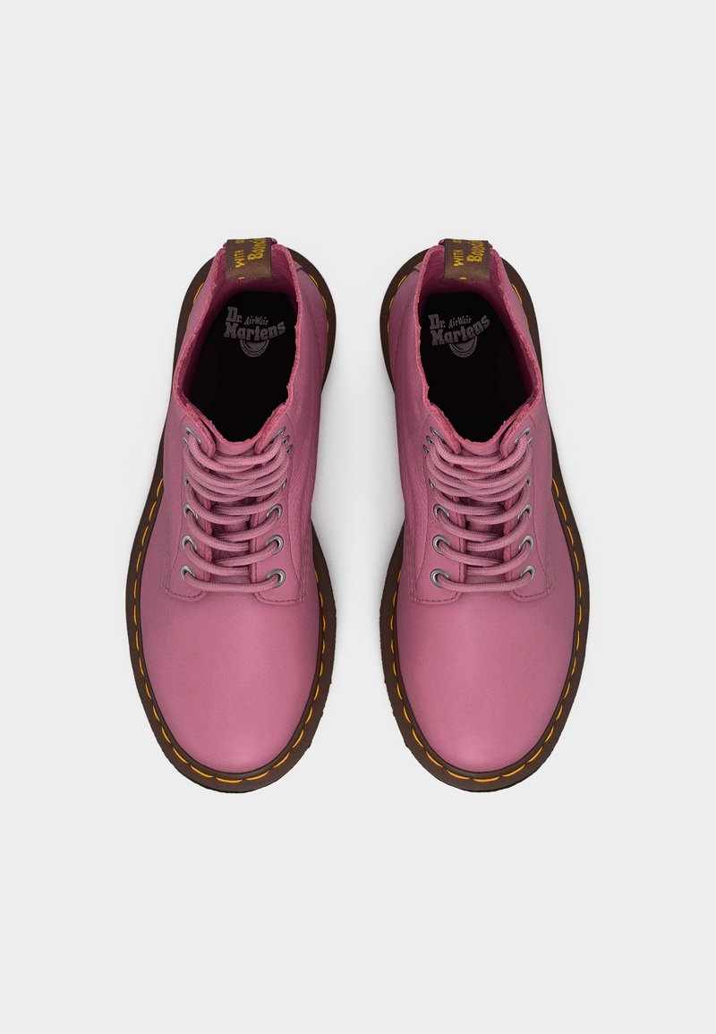 Pair of pink leather lace-up boots with yellow stitching and dark brown soles, viewed from above on white background.