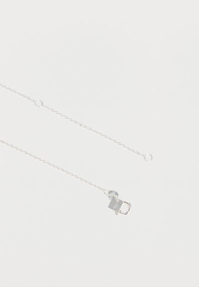 Collier fin en argent avec un petit pendentif en forme de cadenas et un fermoir mousqueton sur fond blanc.