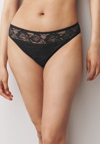 Zwarte kanten bikini met een bloemenpatroon rond de taille, voorzien van een gladde stof en delicate kantaccenten langs de randen.