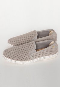 Grijze instappers van geperforeerd suede, met elastische zijpanelen en een witte rubberen zool met een gewoven rand.