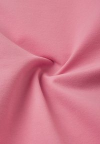 Tela de algodón de un suave color rosa, con una superficie ligeramente texturizada, que muestra pliegues suaves y un acabado liso, ideal para confección o manualidades.