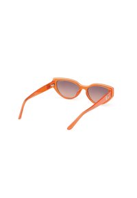 Gafas de sol de plástico naranja con forma de ojos de gato, lentes degradados grises y patillas delgadas y elegantes con un pequeño detalle de logo.