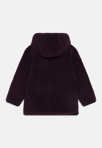 Lila fleecetröja med huva, med en texturerad yta, droppade axlar och svarta detaljer vid ärmsluten. Bakre vy visas.
