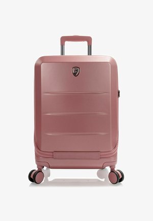 Valigia rigida color oro rosa con superficie testurizzata, manico retrattile, quattro ruote multidirezionali e un logo sulla parte frontale.