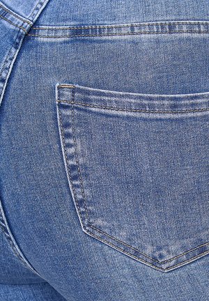 Tissu en denim bleu avec un gros plan d'une poche arrière, présentant des coutures typiques et une texture légèrement décolorée. La forme de la poche est rectangulaire.