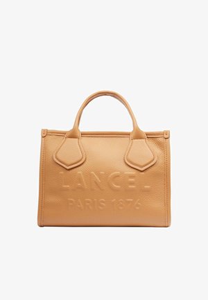 Sac à main en cuir fauve avec deux poignées et texte en relief "LANCEL PARIS 1876" sur le devant.
