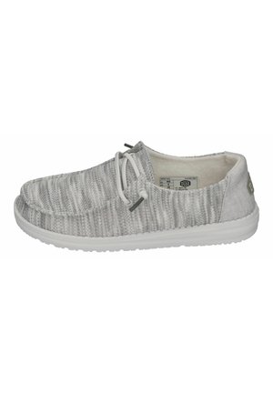 Zapatos de tela gris tipo slip-on con un patrón texturizado, suela de goma blanca y cordones elásticos, con un forro interior suave.