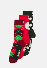 Tre paia di calzini: motivo argyle rosso con verde, rosso uniforme e verde scuro con pois bianchi. Il tessuto presenta la scritta allegra "HAPPY".