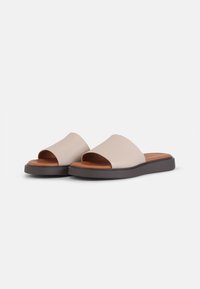 Light beige slide sandals with a smooth textured upper, open toe design, brown rubber sole, and cushioned footbed for comfort.