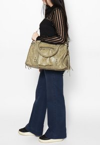 Grande borsa beige testurizzata con tasche frontali e hardware metallico, dotata di manici superiori e di una tracolla removibile.