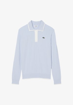 Polo de manga larga azul claro con tejido acanalado, tapeta de botones blanca, ribete blanco en el cuello y logo de cocodrilo verde de Lacoste en el pecho.