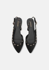 Melnas slingback kurpes ar smailu purngalu, gludu ādas materiālu un zeltītām studēm gar malu. Sprādze uz papēža.