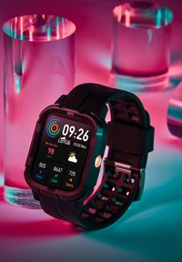 Smartwatch ar kvadrātu formas ciparnīcu, melnu silikona siksniņu un digitālo displeju, kas rāda laiku, sirdsdarbības ātrumu un laika apstākļus. Spilgti krāsu akcenti.