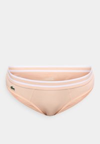 Μπεζ ριγωτό μπικίνι εσώρουχο με λευκή ριγέ ελαστική ζώνη μέσης και μικρό πράσινο λογότυπο κροκοδείλου στο αριστερό μπροστινό μέρος.