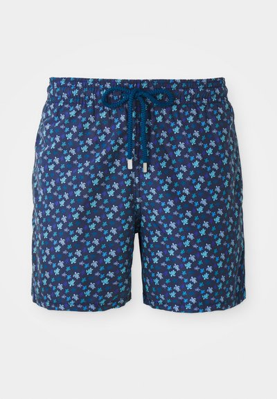 Plavalne hlače v mornarsko modri barvi s cvetličnim vzorcem v odtenkih modre in turkizne. Imajo elastiko za nastavitev pasu.