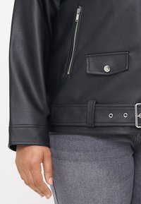 Black faux leather jacket featuring a zippered chest pocket, snap-button flap pocket, belt detail, and wide cuffs. Textured, structured design.