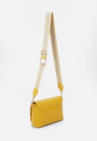 Gul läderaxelväska med en platt form, magnetisk klaffstängning och en mönstrad justerbar rem med "Valentino"-logotypen.