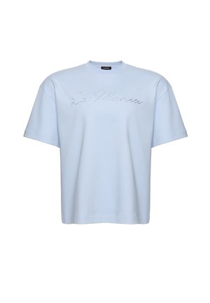 Tricou bleu deschis cu mânecă scurtă, croială lejeră, guler rotund și textul „La Mania” scris cu mici strasuri pe piept.