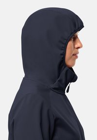 Geacă softshell navy, cu glugă ajustată. Dispune de un guler înalt, fermoar frontal și o textură exterioară netedă.