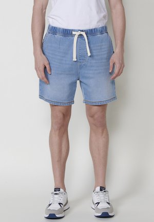 Lichte blauwe denim shorts met een elastische tailleband, witte trekkoord en een relaxte pasvorm. Beschikt over een rafelige zoom en ontwerp met vijf zakken.