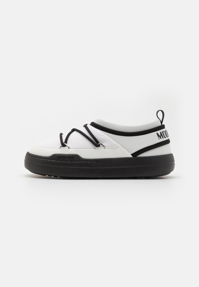 Pantofi albi tip slip-on cu accente negre, având o talpă din cauciuc netedă, șireți elastici și un material superior texturat pentru aderență și suport.