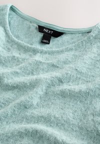 Hellminzgrüner Pullover aus weichem, flauschigem Material. Verfügt über einen U-Boot-Ausschnitt und das sichtbare Markenetikett "NEXT". Ganzflächiges strukturiertes Muster.