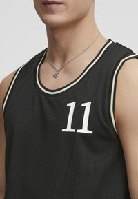 Sort atletisk tanktop med mesh-struktur, prydet med det hvide tal "11" på fronten, accentueret med lys grå kant langs halsudskæringen og ærmegab.