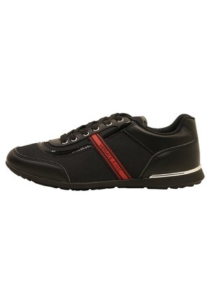 Sort lav sneaker med sorte snørebånd, rød sidestreg mærket "Versace Jeans," og hvid detalje på sålens hæl.