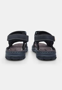 Mustad mustad reguleeritavate rihmadega. Ümar varvas, tekstureeritud sisetallad ja robustne, mustritustatud välistald, mis tagab haarde ja vastupidavuse.