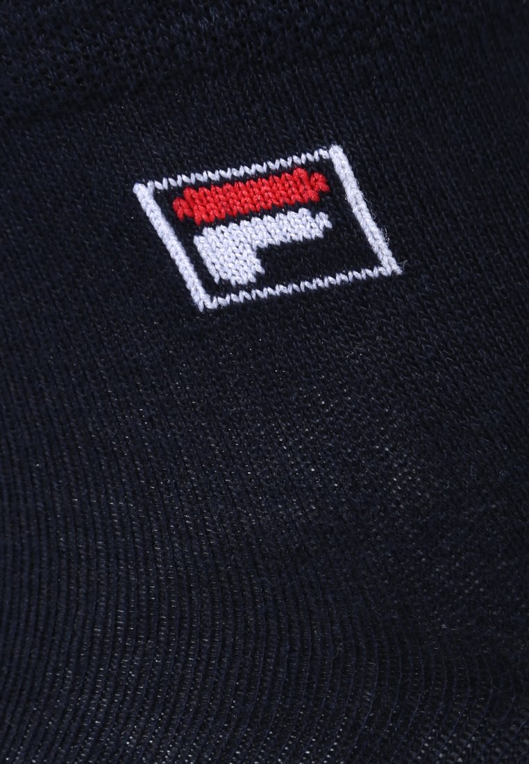 Tessuto nero con finitura testurizzata che presenta un logo Fila in rosso, bianco e nero in forma rettangolare, ricamato sulla superficie.