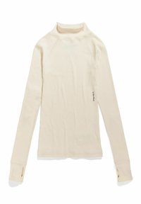 Top de manga larga color crema, con un cuello tipo mock y canalé, que cuenta con orificios para los pulgares en los puños y un pequeño logo cerca del dobladillo.