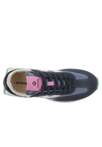 Sneaker blu navy con accenti rosa, realizzato con una combinazione di suede e materiali sintetici, punta arrotondata e suola testurizzata. Logo sulla linguetta.