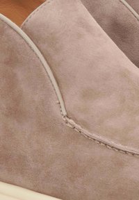 Zijdeachtige mauve schoen met een zachte textuur. Heeft contrasterende beige stiksels en een afgeronde neus.