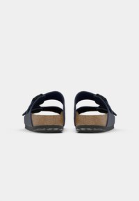 Sandales bleu marine avec un semelle en liège, dos ouvert et double brides. Présente une semelle extérieure en caoutchouc avec une texture antidérapante pour plus de stabilité.