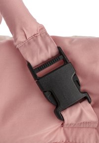 Rosa Stoff mit matter Textur und schwarzer Plastikschließe. Die Schließe hat eine konturierte Form und einen zentralen Versteller zum Sichern der Riemen.