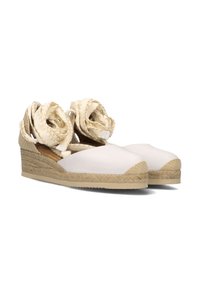 Witte leren espadrille wedge sandalen met gevlochten jute zolen, voorzien van gevlochten beige banden die om de enkels zijn gewikkeld, met gesloten neus ontwerp.