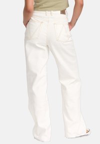 Hoge taille witte wijde broek van denim, met contrasterende stiksels, twee achterzakken met schuine kleppen en een klein merkje.