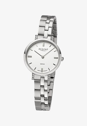 Montre-bracelet en métal argenté avec cadran blanc, index horaires minimalistes, aiguilles fines et bracelet à maillons, ornée de petits cristaux décoratifs.