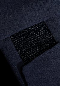 Marineblauwe stof met een gestructureerde zwarte patch, met een geluschte oppervlak. Soepele en zachte textuur met schone randen en geen zichtbare hardware.