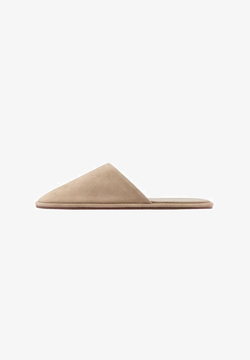 Beige suede slip-on shoe with a pointed design, flat sole, and smooth texture. Minimalist style with no visible hardware or embellishments.