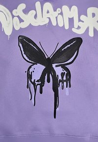 Farfalla nera con effetto vernice gocciolante e testo in stile graffiti bianco su sfondo di tessuto viola.