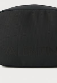 Μαύρο καλλυντικό τσαντάκι με ανάγλυφο λογότυπο "VALENTIN", ορθογώνιο σχήμα και λείες άκρες για κομψό σχεδιασμό.