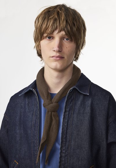 Brauner Schal um den Hals gebunden, über einem blauen Hemd getragen, unter einer Jeansjacke mit Kontrastnähten und einem Reißverschluss.
