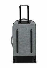 Valise grise à coque souple avec une poignée télescopique noire extensible, deux roues et une poignée de transport latérale, vue de l'arrière.