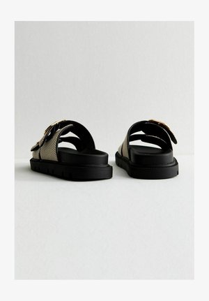 Czarne i beżowe sandały na slip-on z teksturowanym paskiem i masywną gumową podeszwą, z złotym akcentem na detalu klamry.